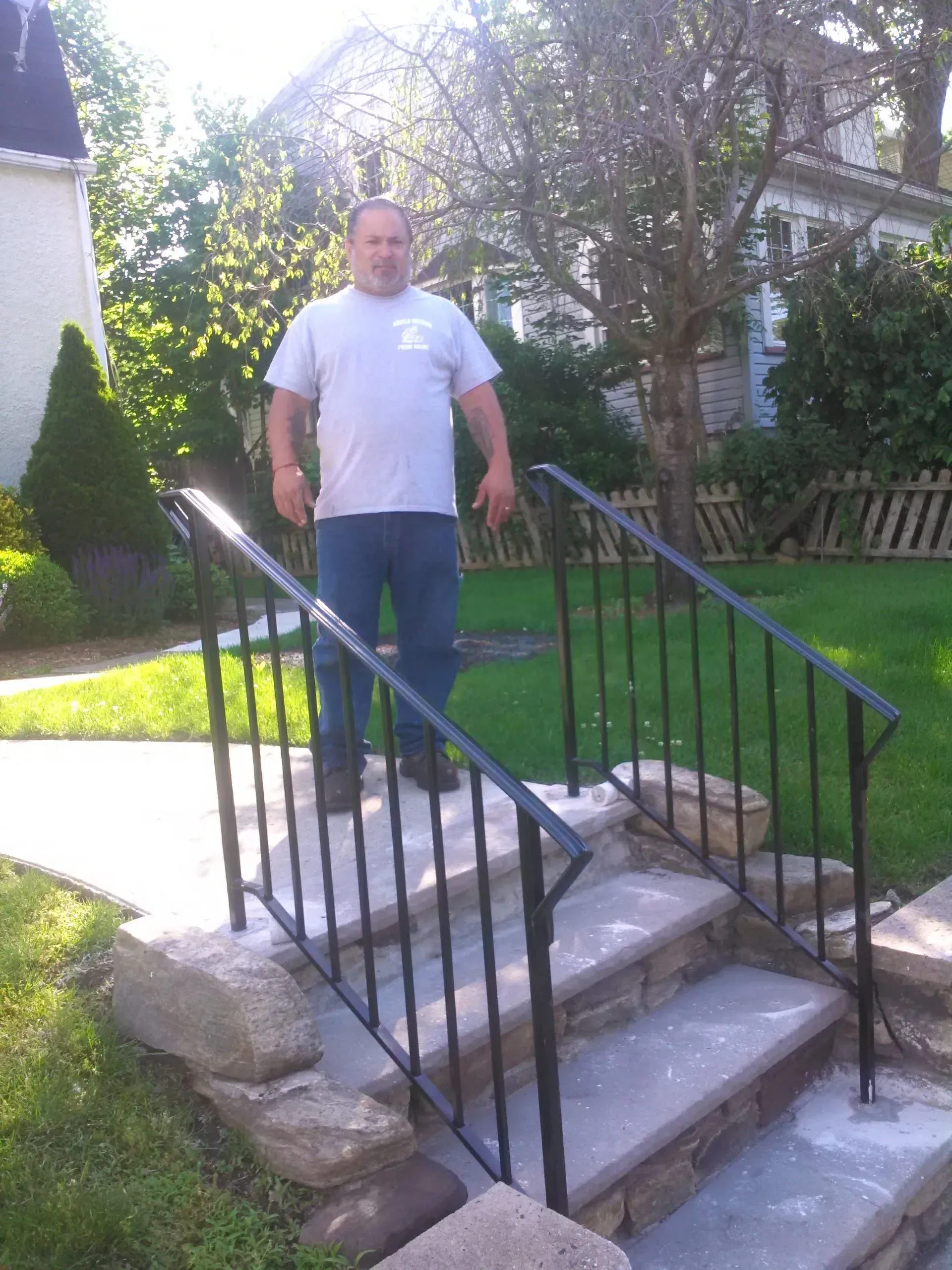 A man standing on a set of stairs with a metal railing.