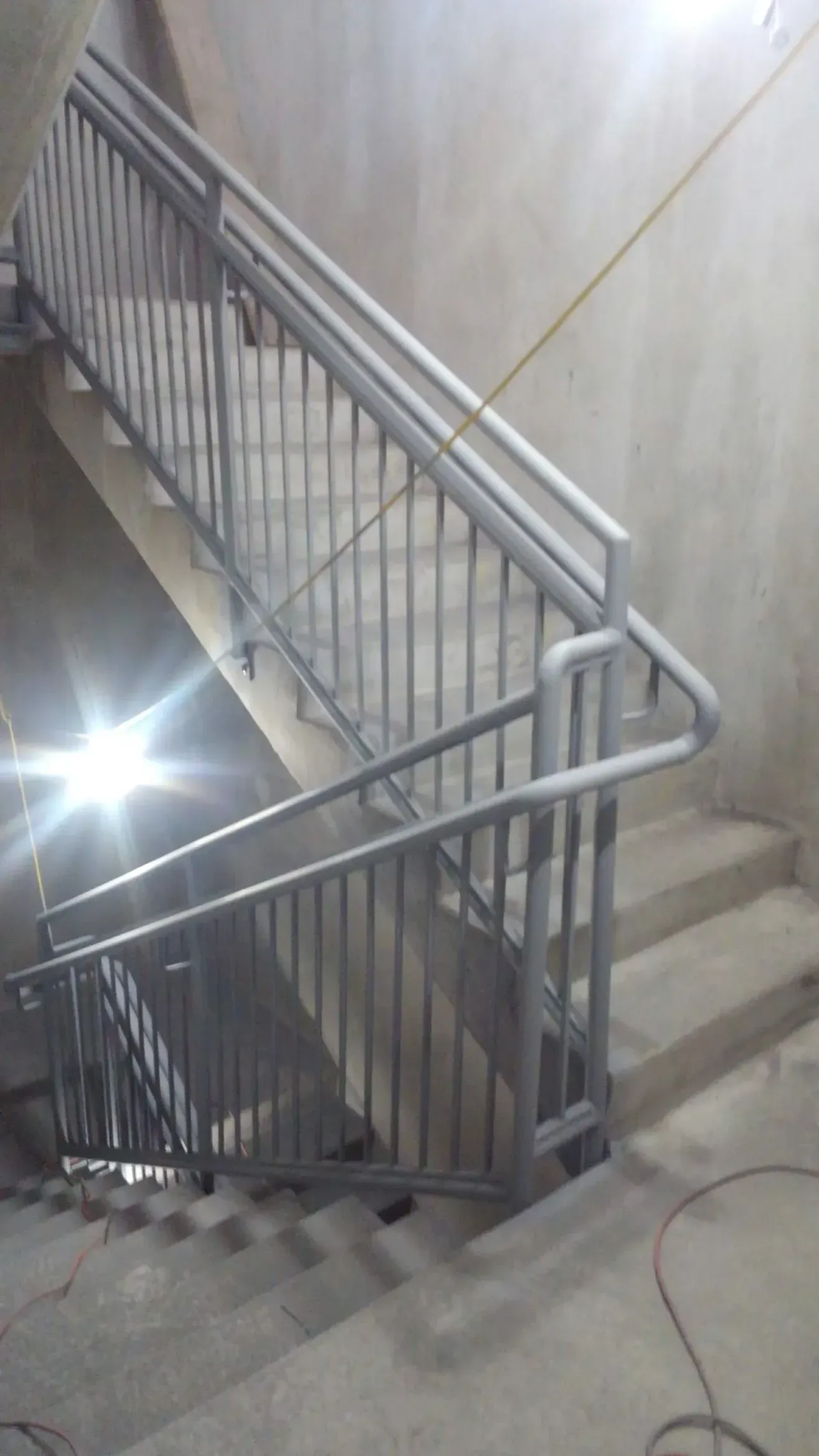A staircase with a metal railing is being built in a building.
