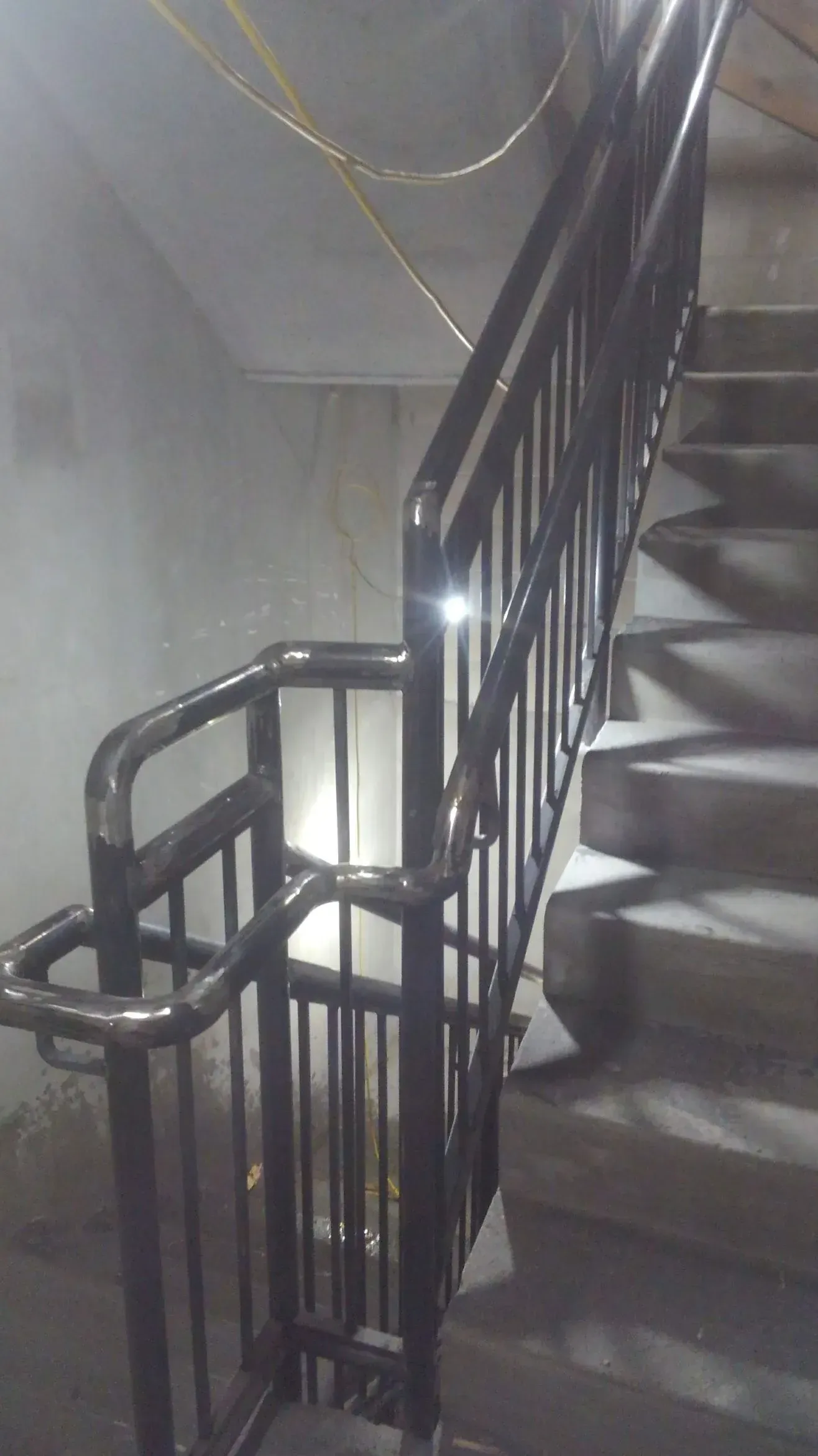 A close up of a metal railing on a set of stairs.