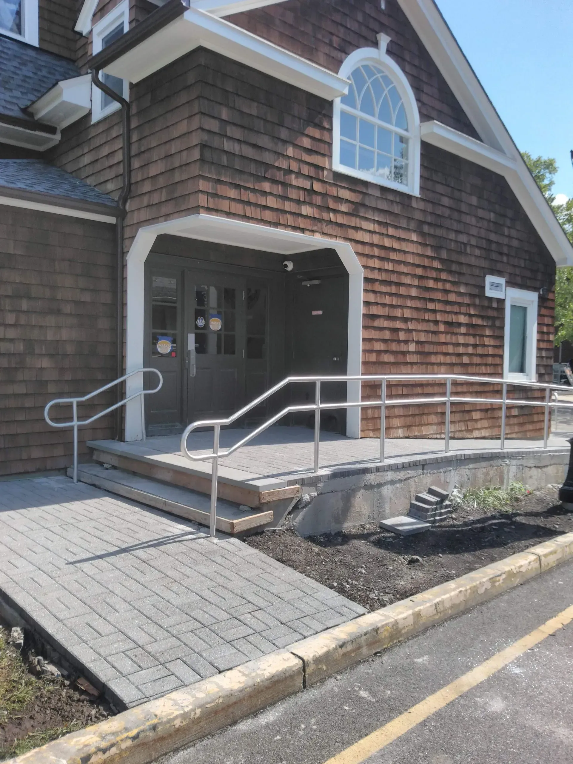A brick building with a ramp leading to the front door.