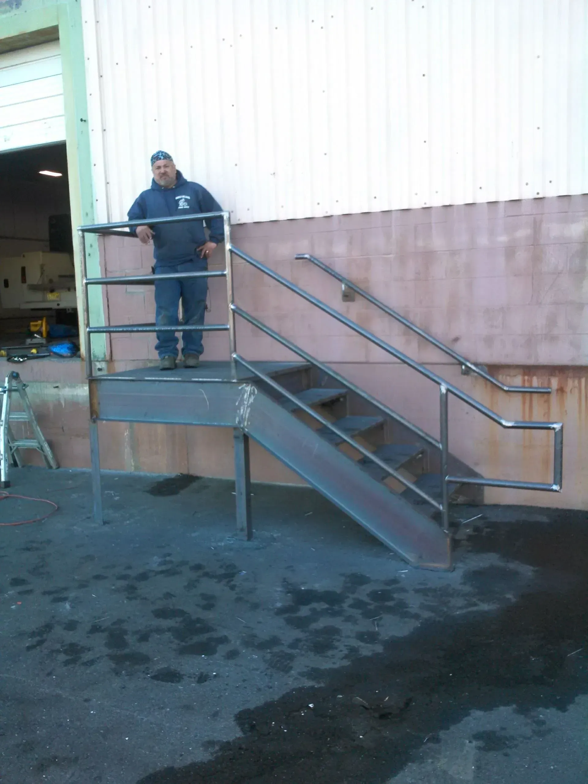 A man is standing on a set of metal stairs.