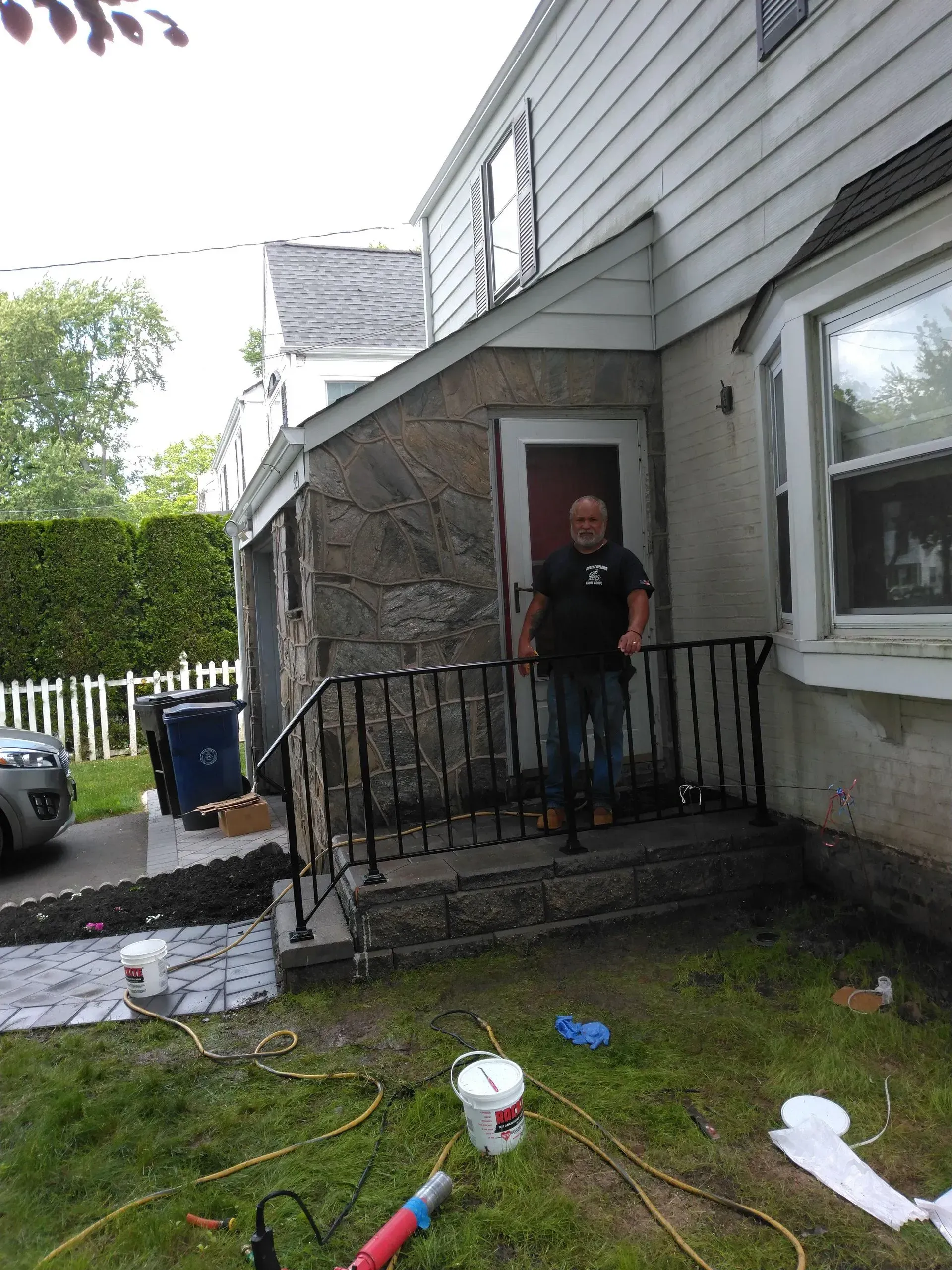 A man is standing on the porch of a house.