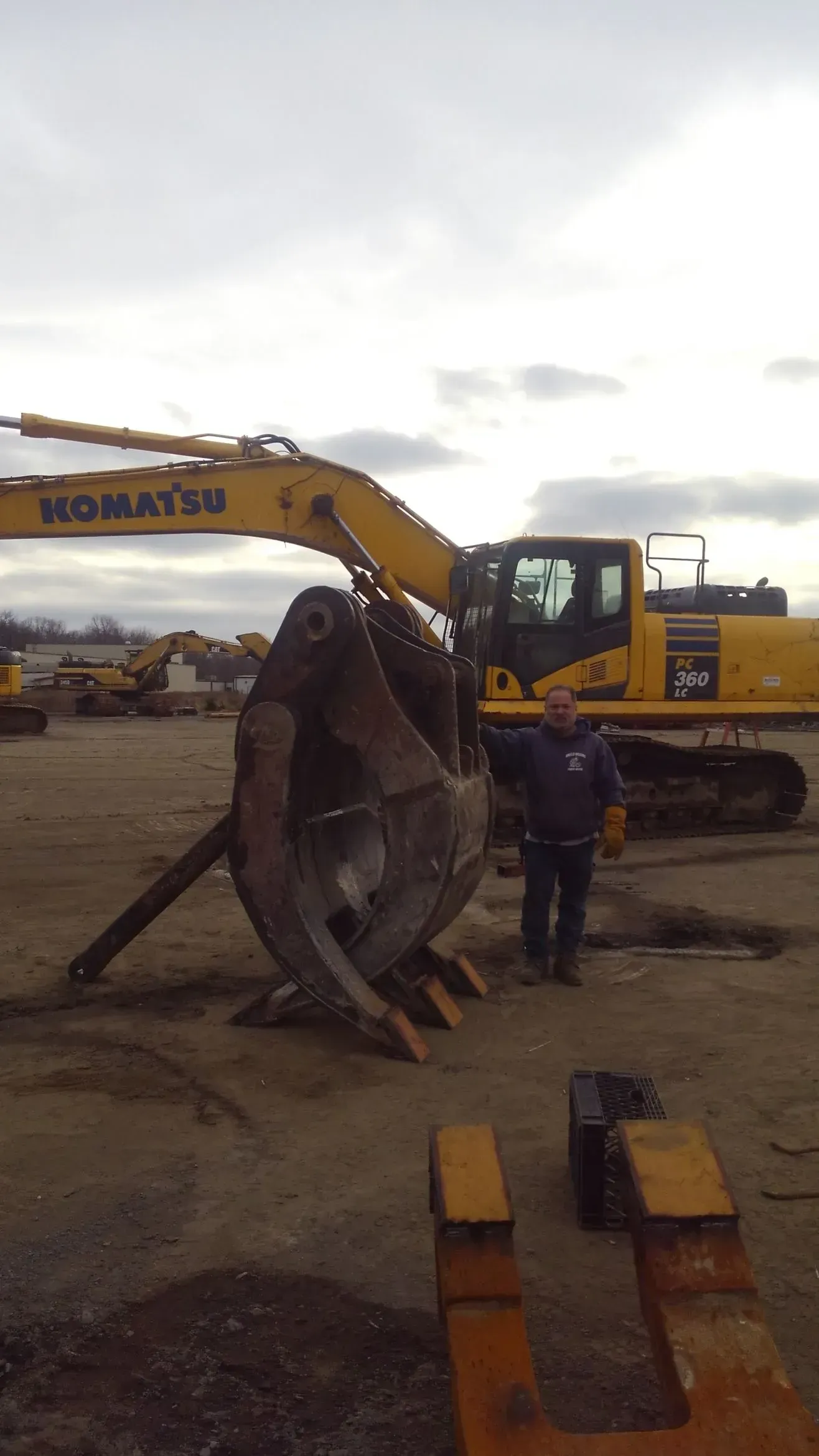 A man is standing in front of a komatsu excavator.