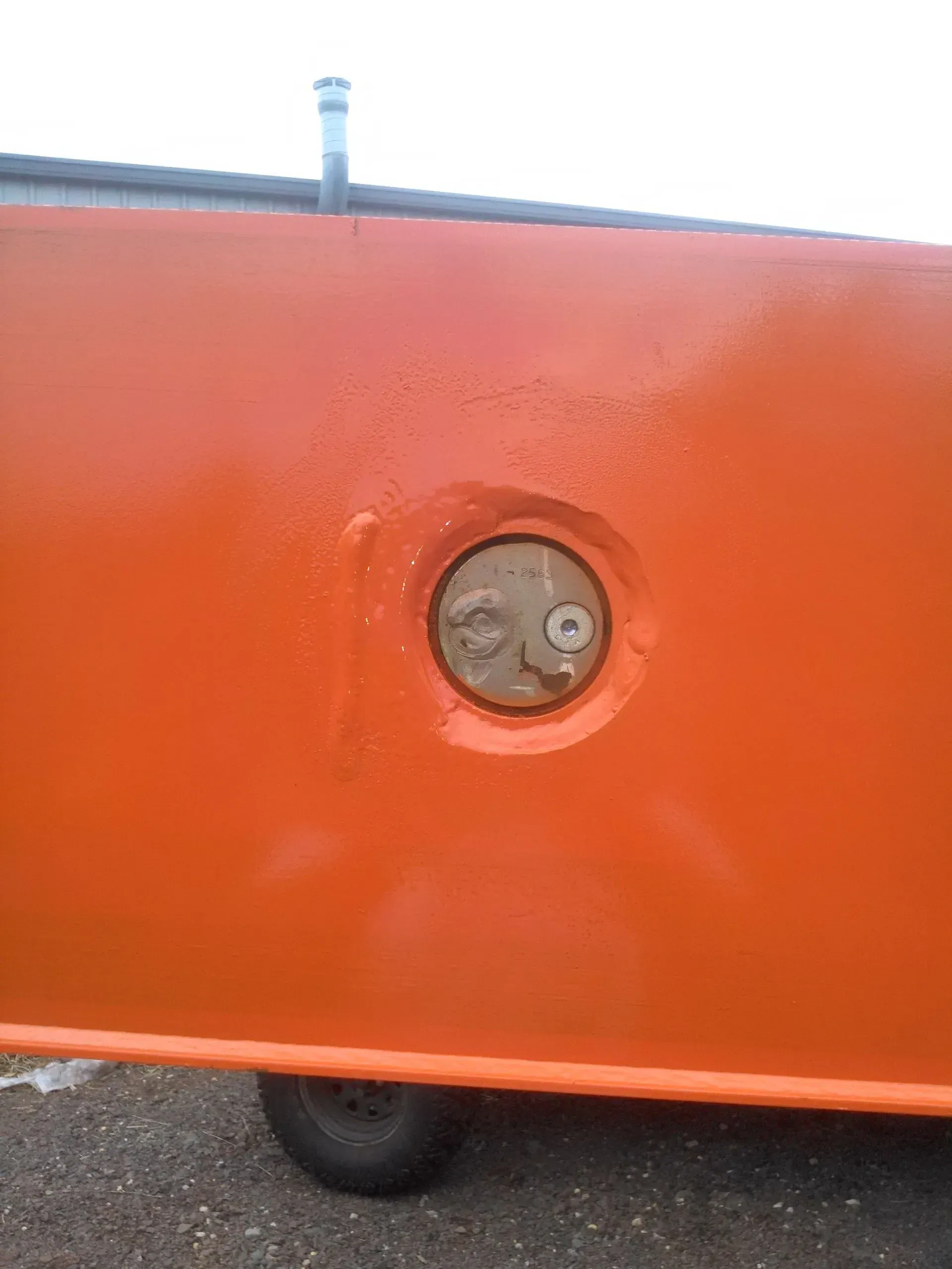 A close up of an orange wall with a hole in it.