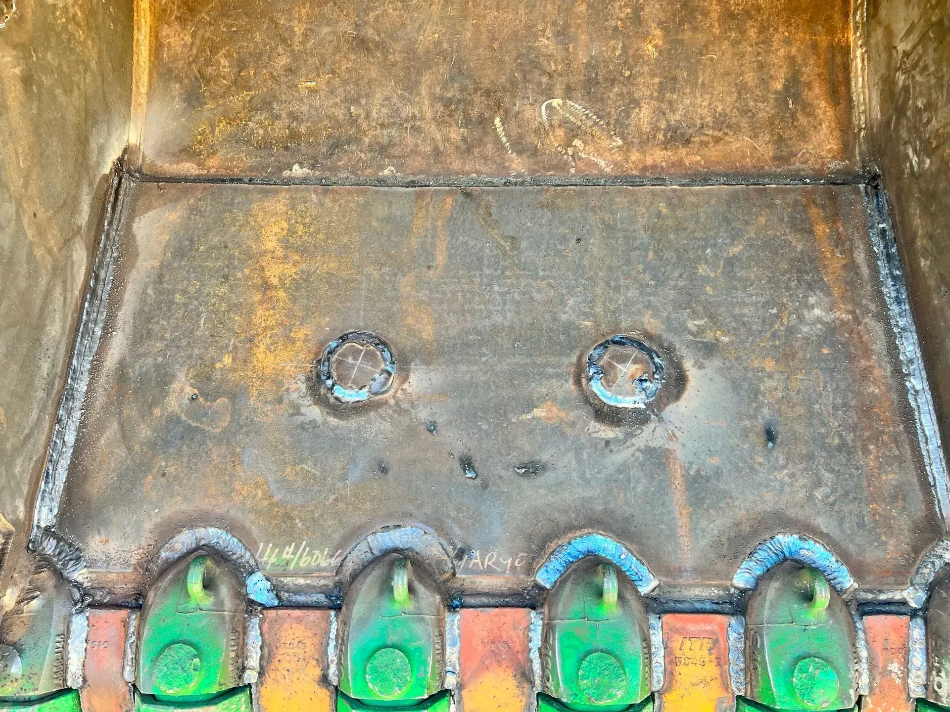 A close up of a rusty metal surface with green holes in it.