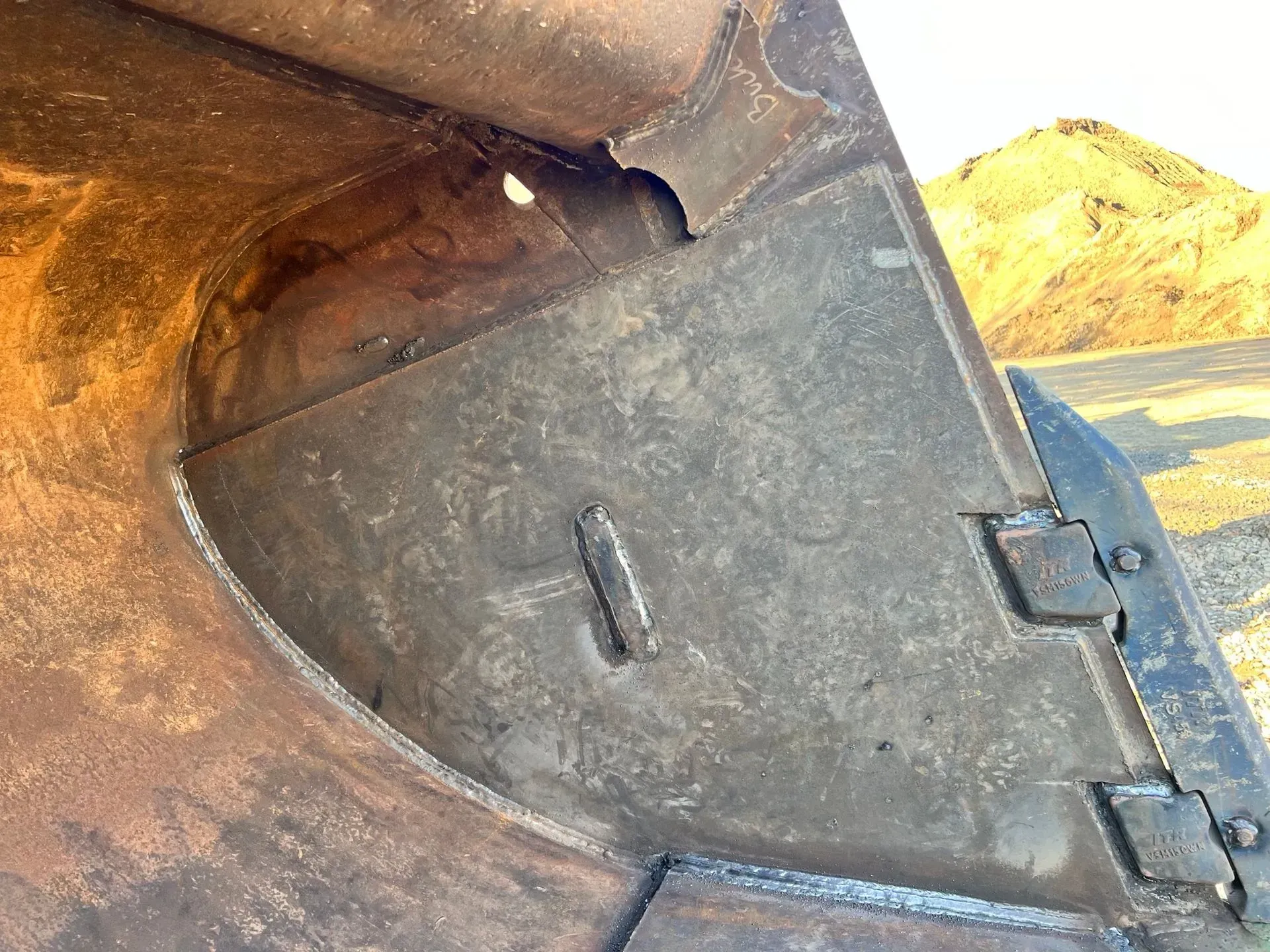 A close up of a metal object with a mountain in the background.
