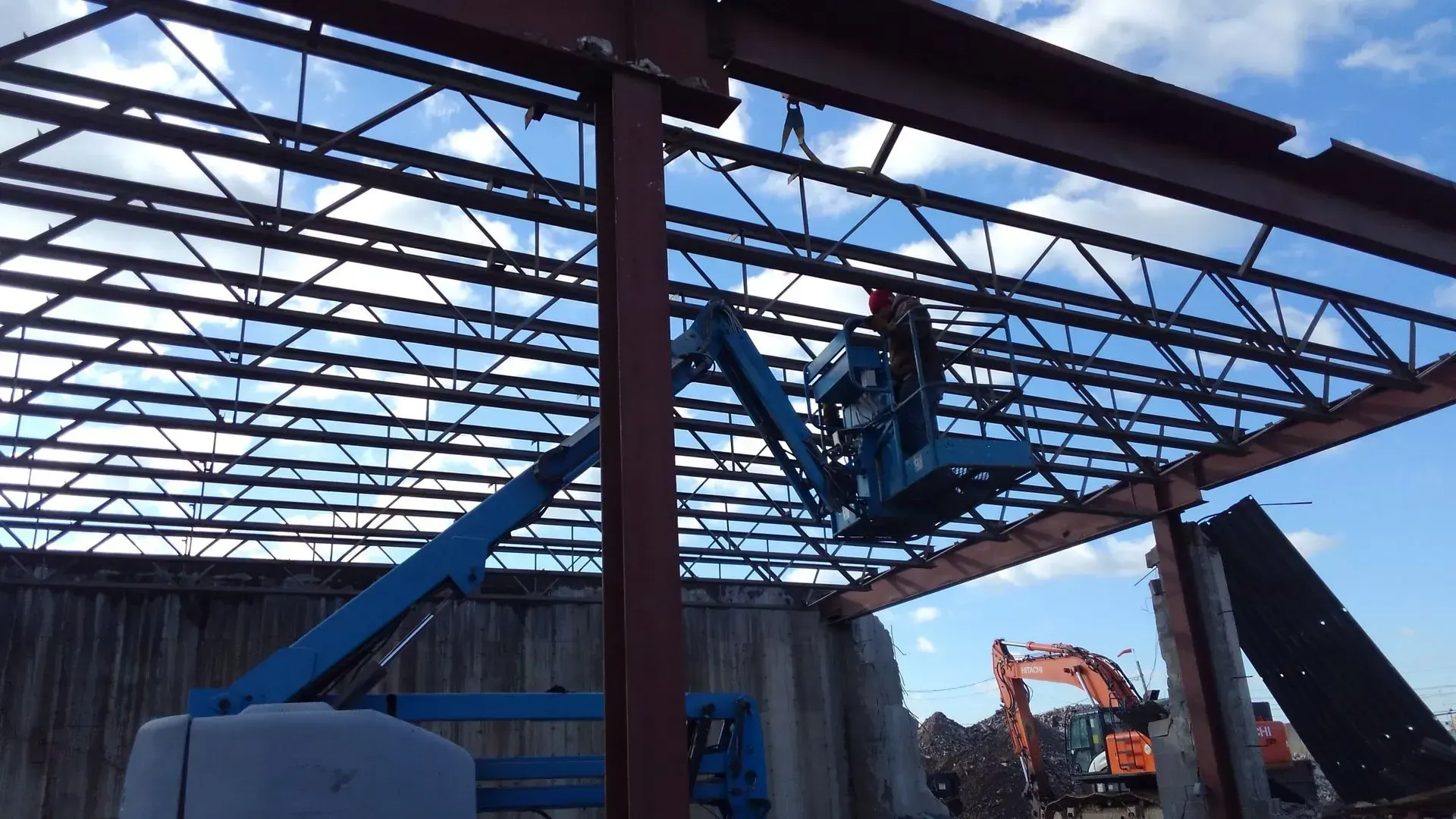 A man on a lift is working on the roof of a building.