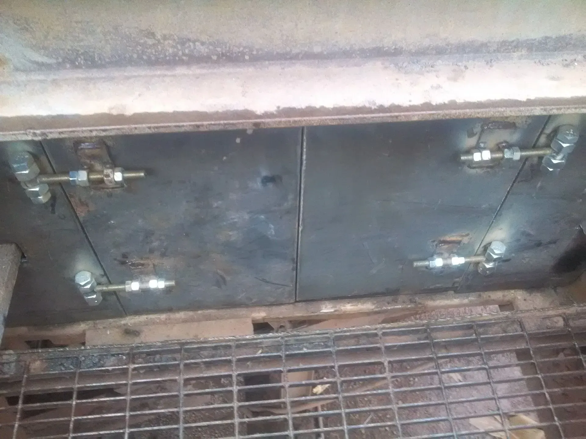 A metal door with a metal grate underneath it.