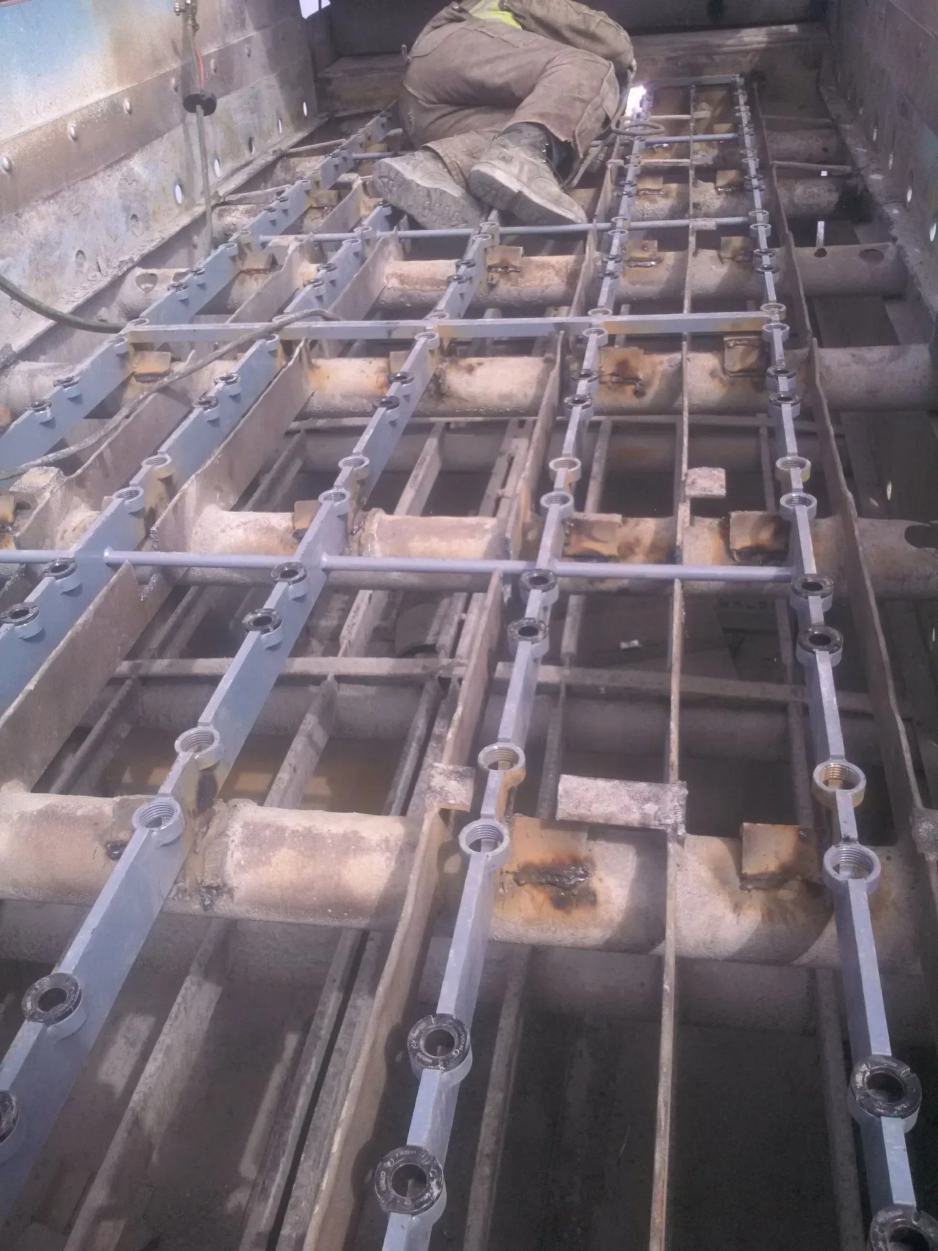 A metal structure with a lot of pipes going through it.