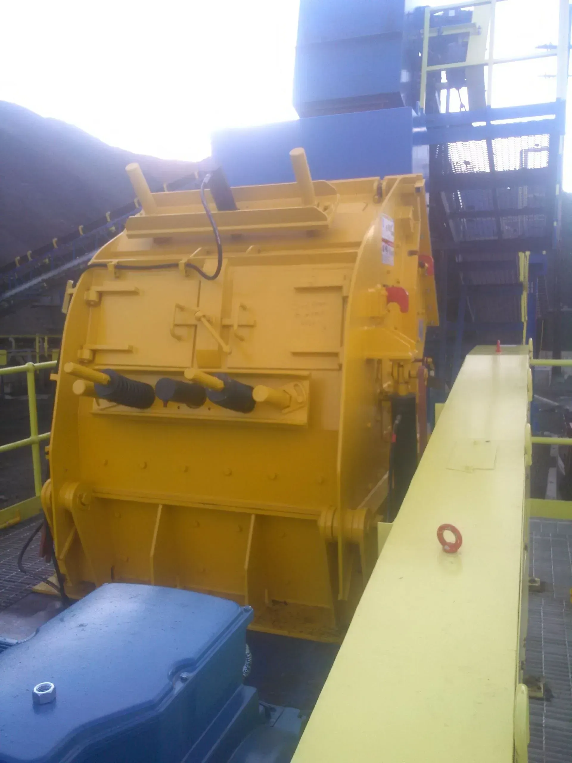 A large yellow machine is sitting next to a blue machine.