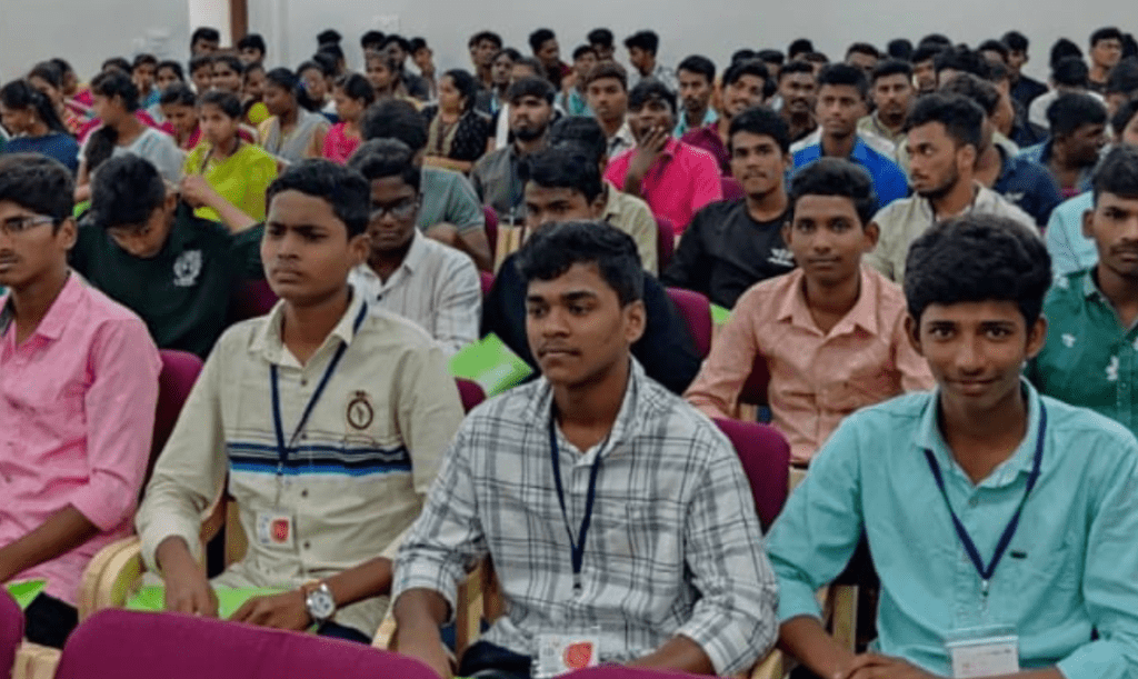 A group of young adults are sitting in chairs in a room.