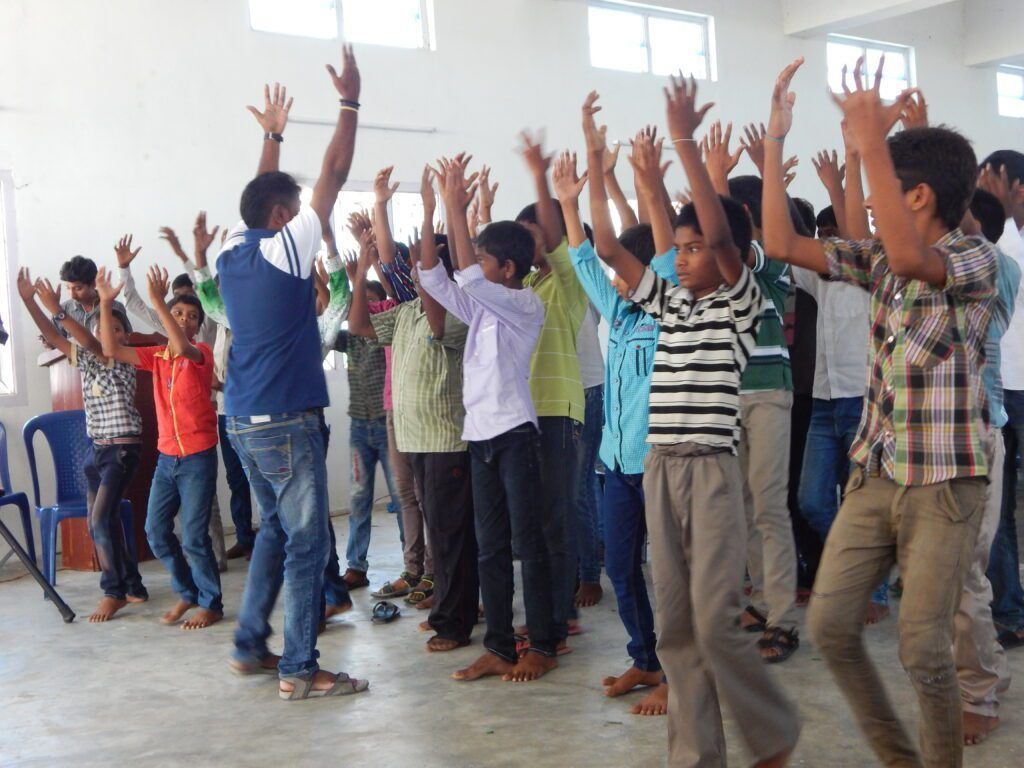 A group of young men are dancing with their hands in the air