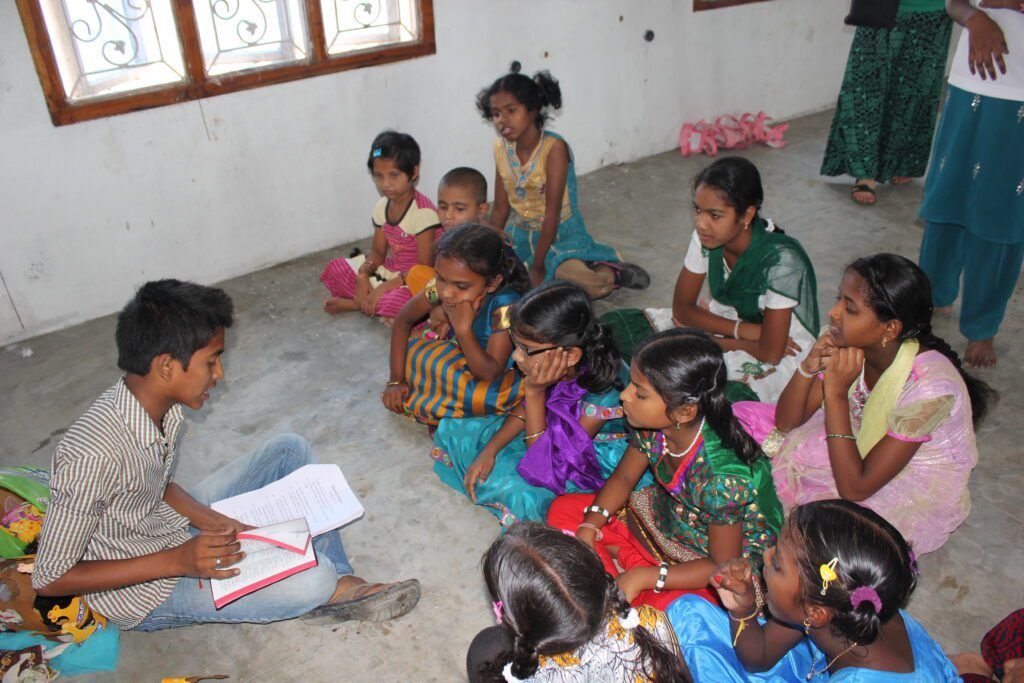 A group of children are sitting in a circle on the floor