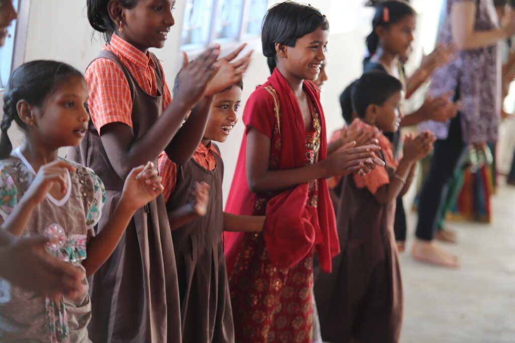 A group of children are clapping their hands together