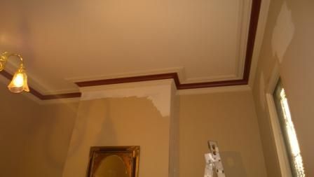 A room with a picture on the wall and a ladder in the corner.