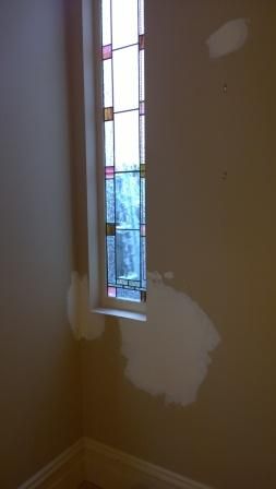 There is a stained glass window in the corner of the room.