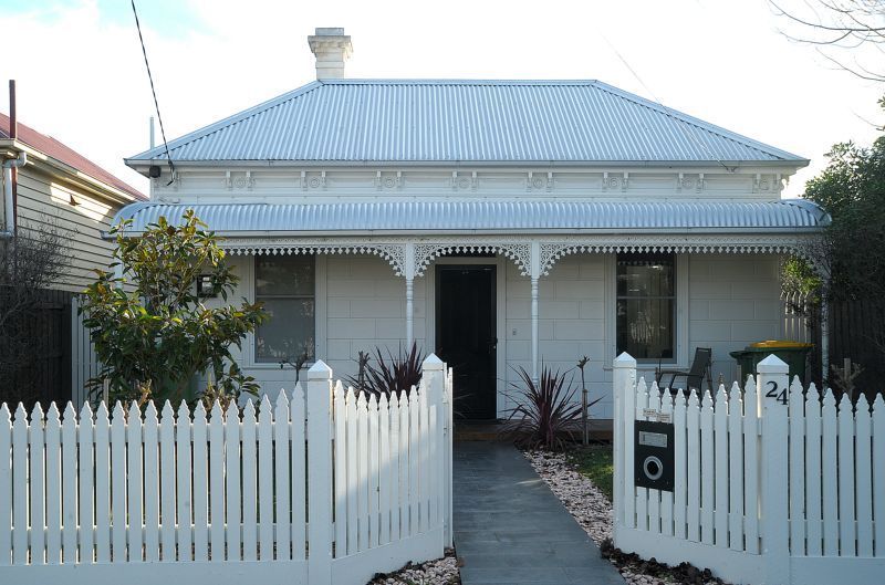 A white house with a white picket fence and a mailbox