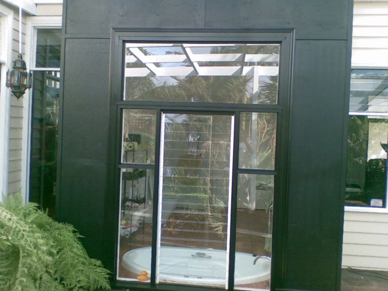 A house with a sliding glass door leading to a hot tub