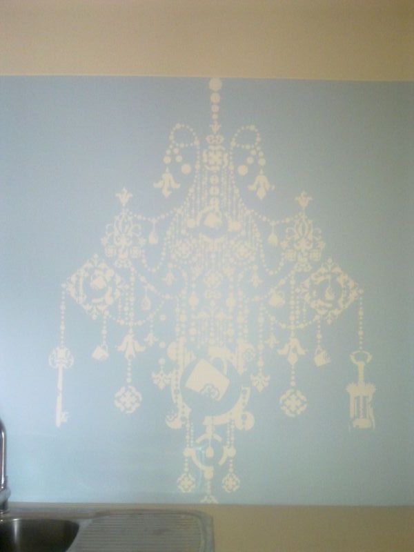 A blue splashback with a white chandelier design