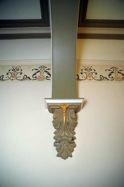 A shelf with a cross on it is on a wall