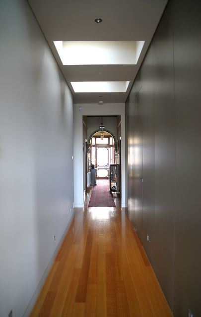 A long hallway with wooden floors and white walls