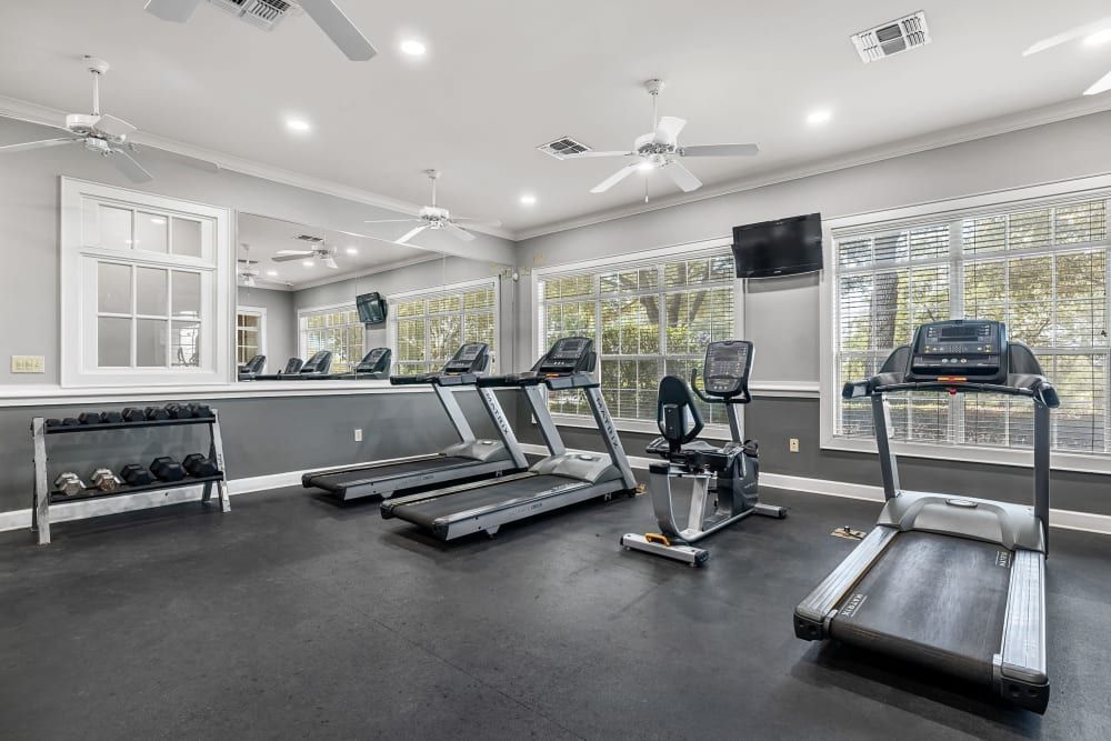 A gym with treadmills, a bike, and a mirror at Marquis at The RIM in Northwest San Antonio, TX.