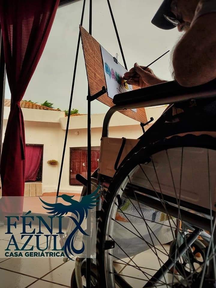 Un hombre en silla de ruedas está pintando un cuadro