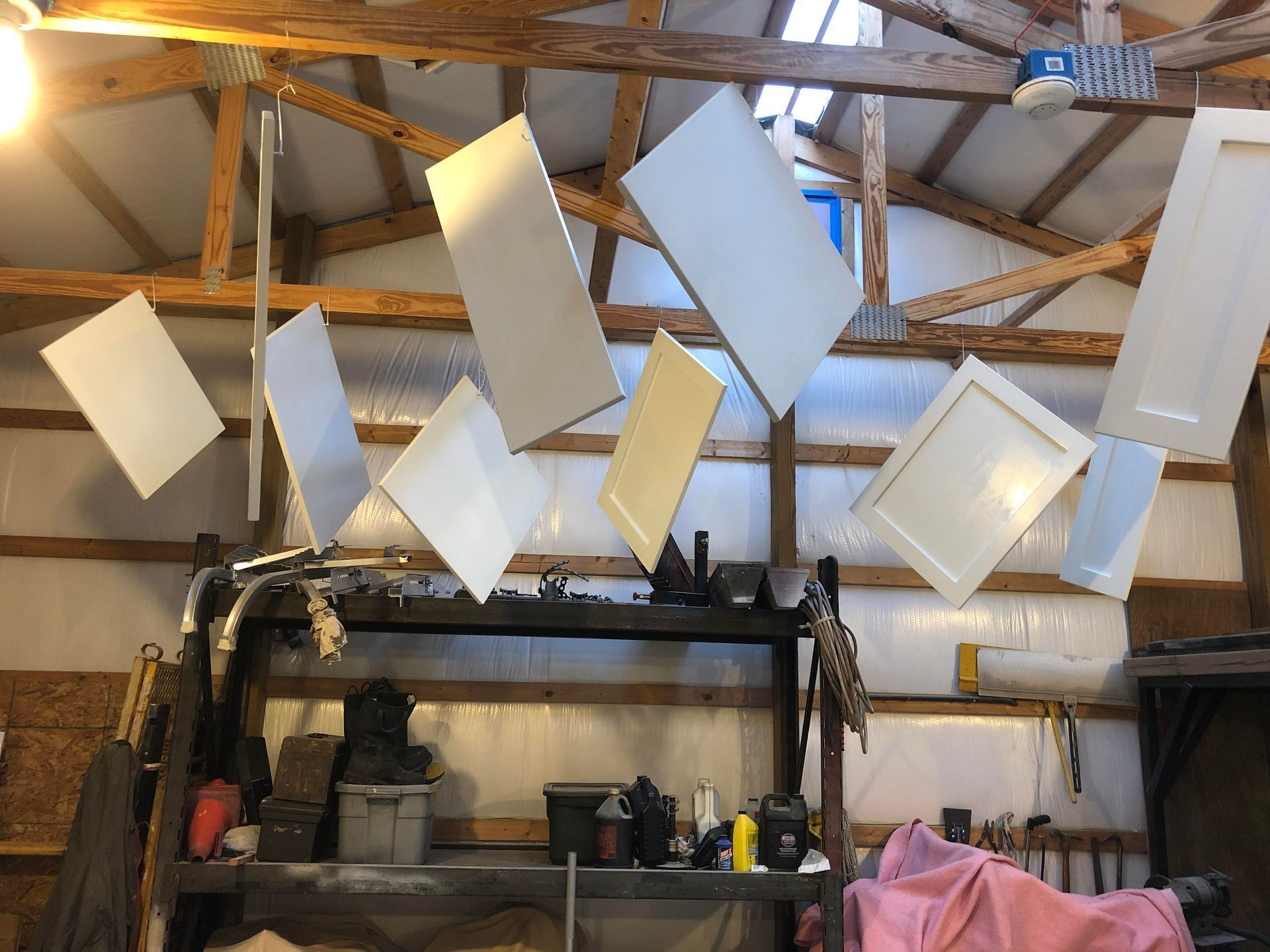 Workshop ceiling with hanging white rectangular panels and shelves below
