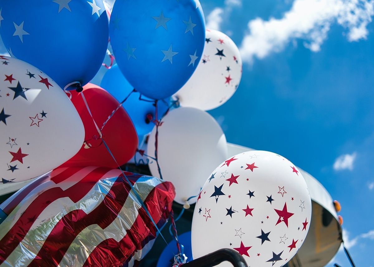 A bunch of red white and blue balloons with stars on them