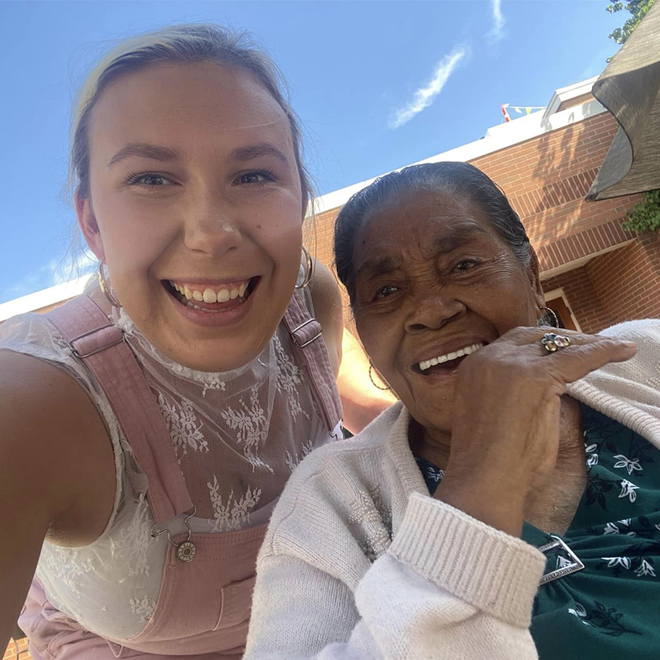 A young woman is taking a selfie with an older woman.