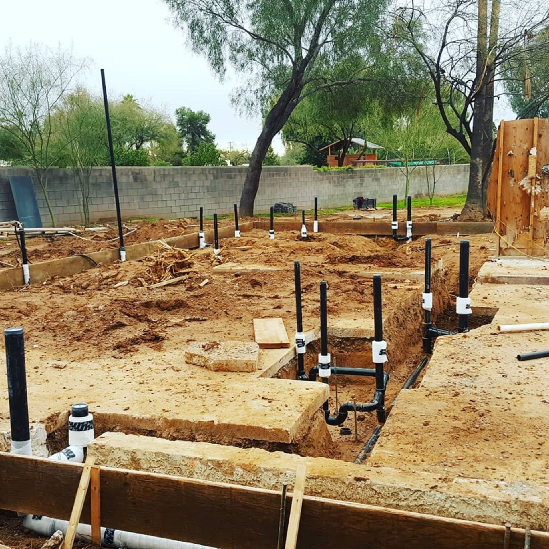 A construction site with a lot of pipes in the dirt