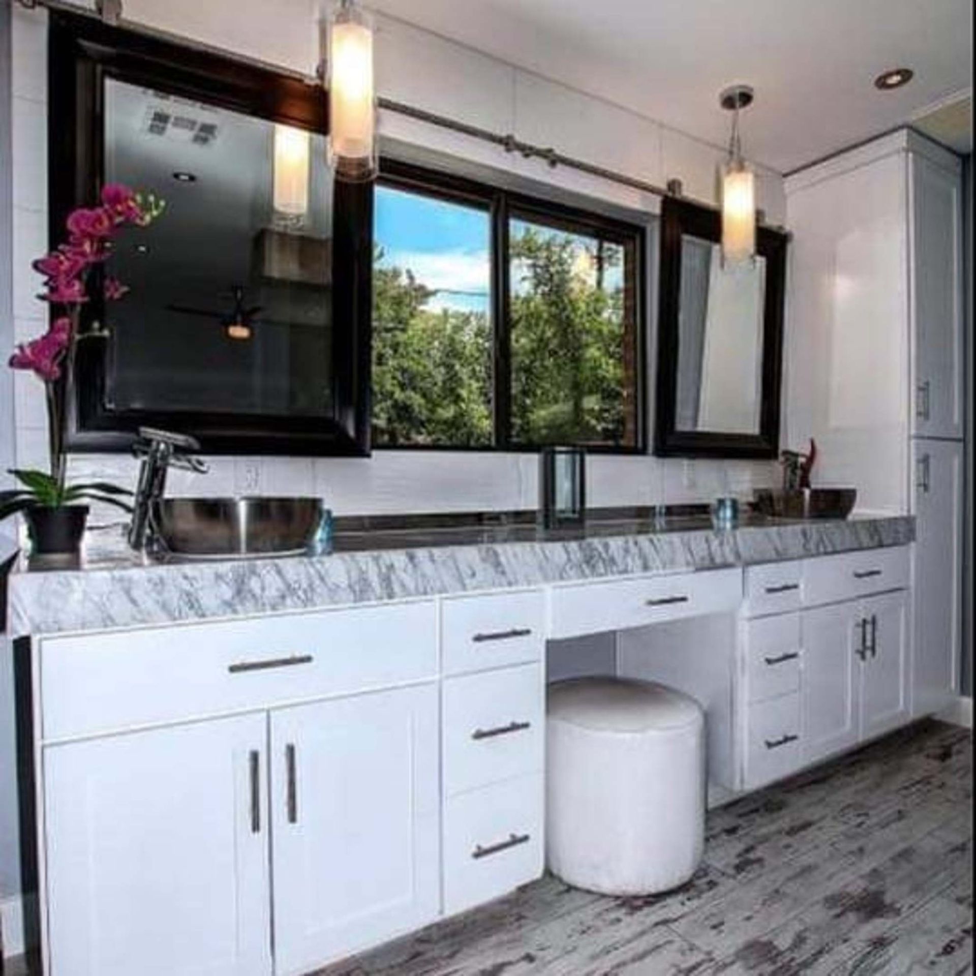 A bathroom with two sinks , two mirrors , and a stool.