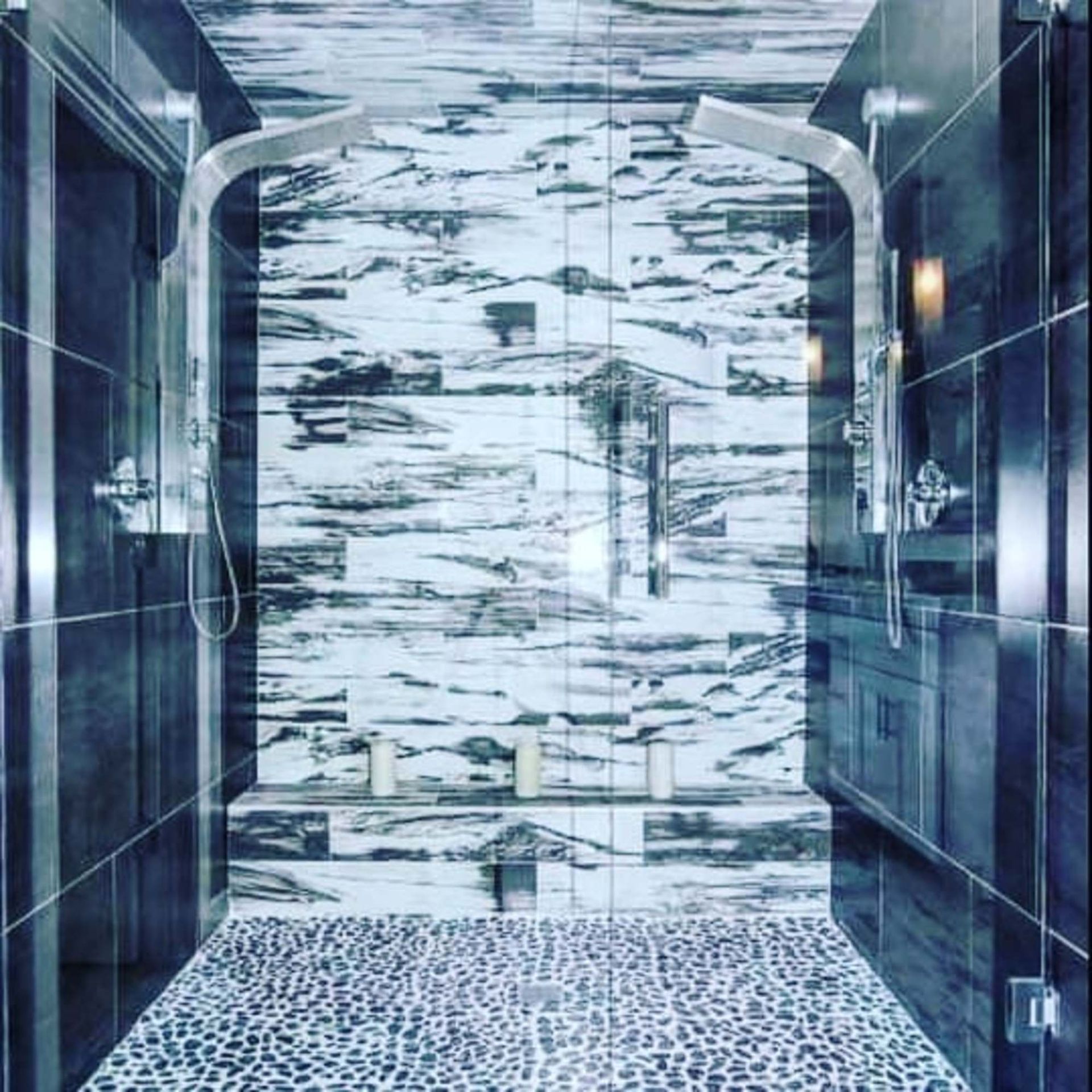 A bathroom with black and white tiles and a walk in shower