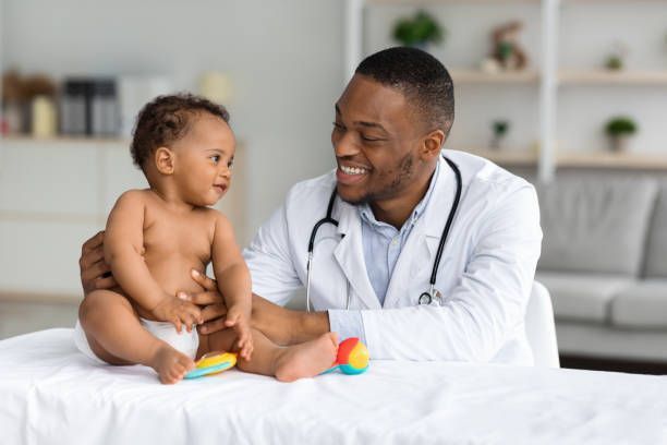 Portrait of Smiling Doctor Making Check Up for Infant Baby Boy — Flowood, MS — Capital City Children & Adolescent Clinic, PLLC