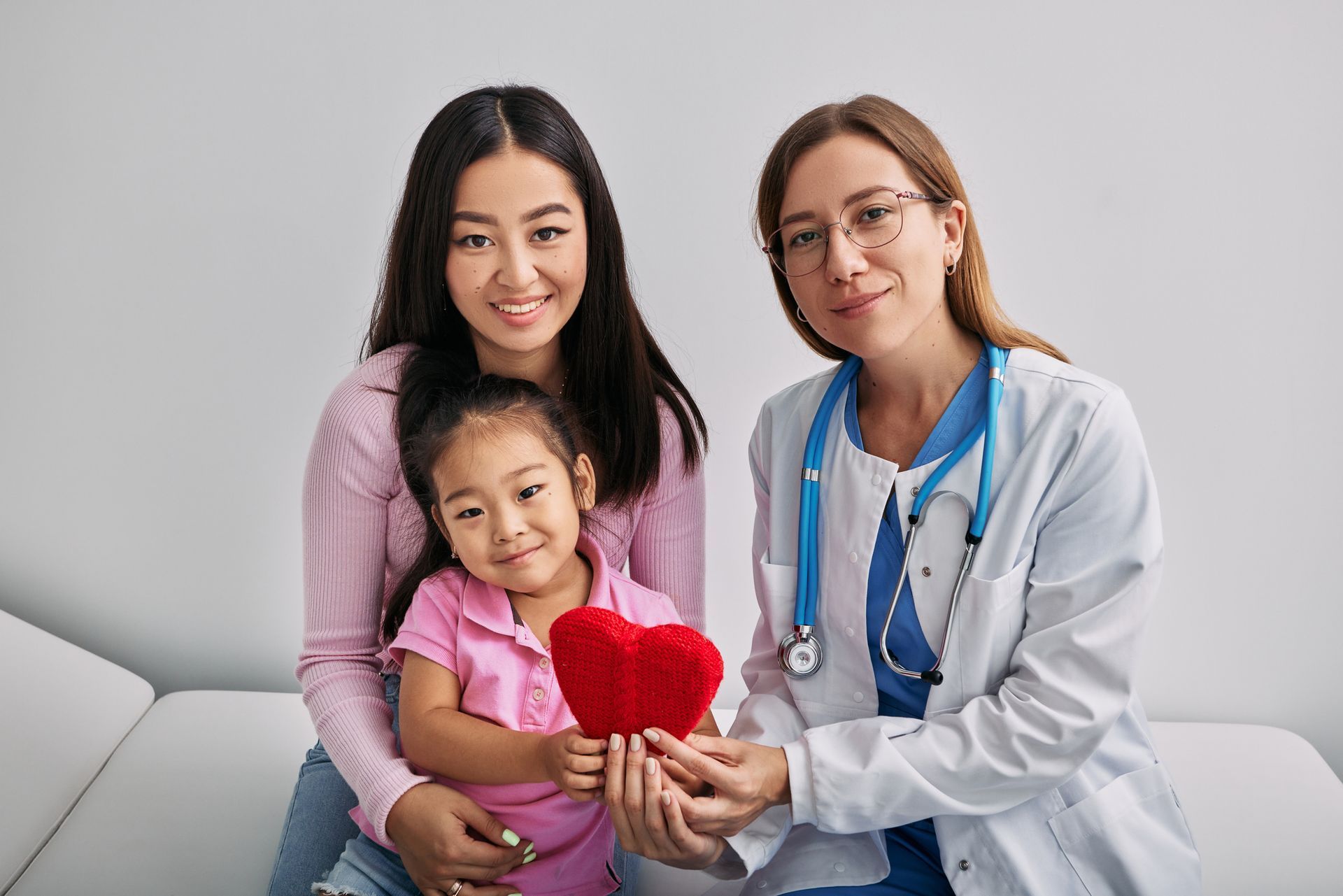 Asian Woman with Healthy Daughter Sitting Together with her Pediatrician — Jackson, MS — Capital City Children & Adolescent Clinic, PLLC