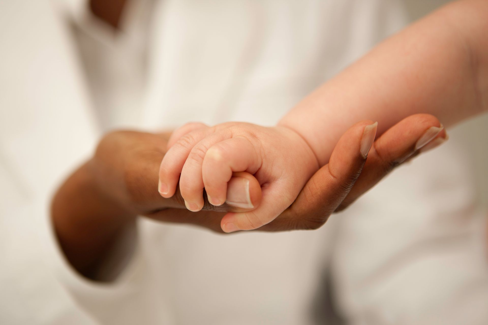 Interracial Doctor Holding Baby's Hand — Brandon, MS — Capital City Children & Adolescent Clinic, PLLC