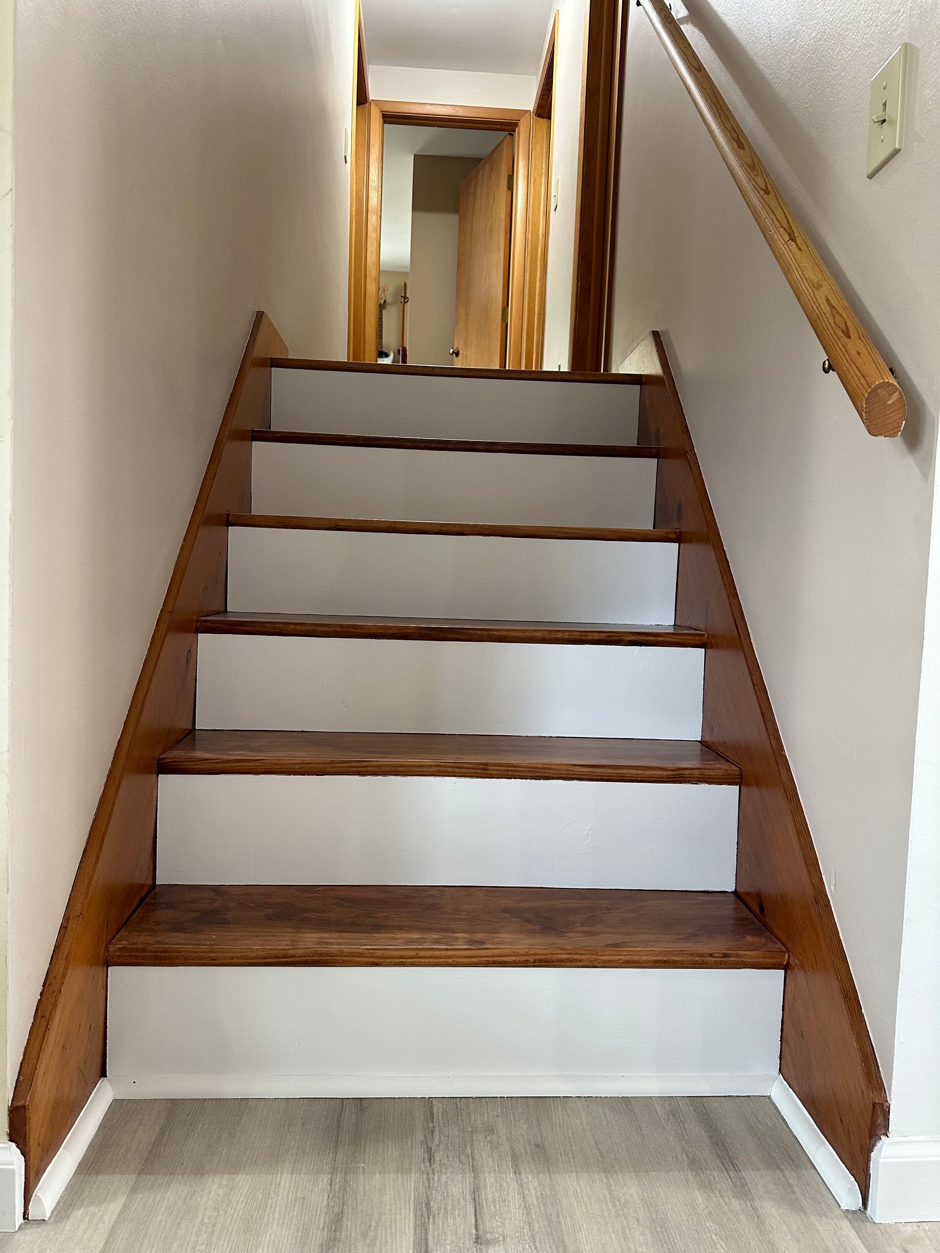 A wooden staircase with white steps in a house