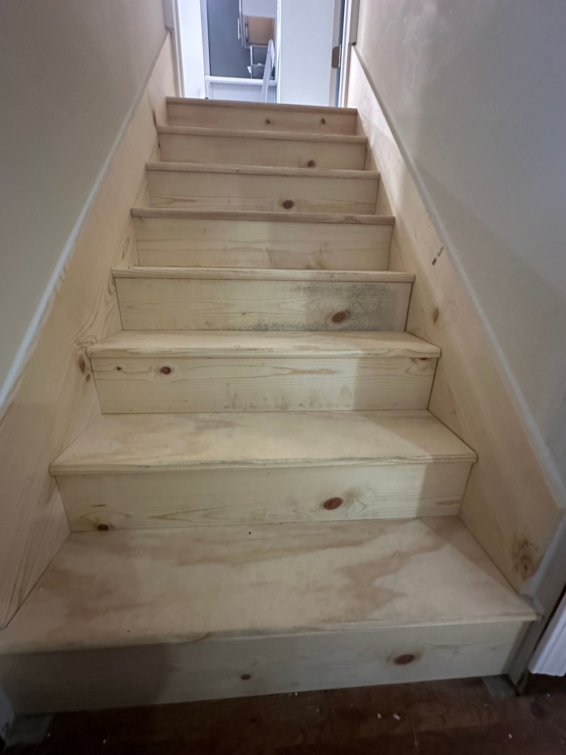 A wooden staircase is being built in a house.