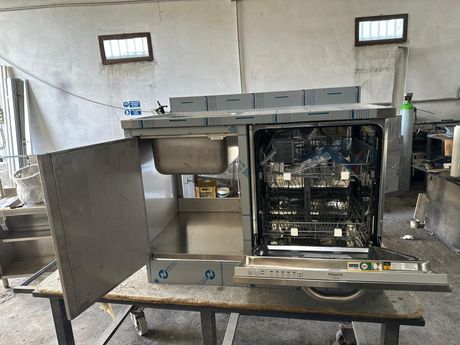 Forno professionale in acciaio inox con sportello aperto in una cucina industriale.