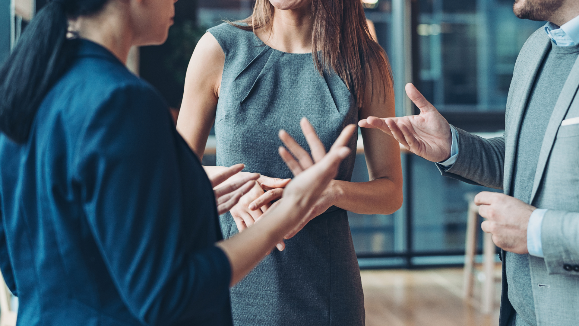 A group of people are talking to each other in an office.