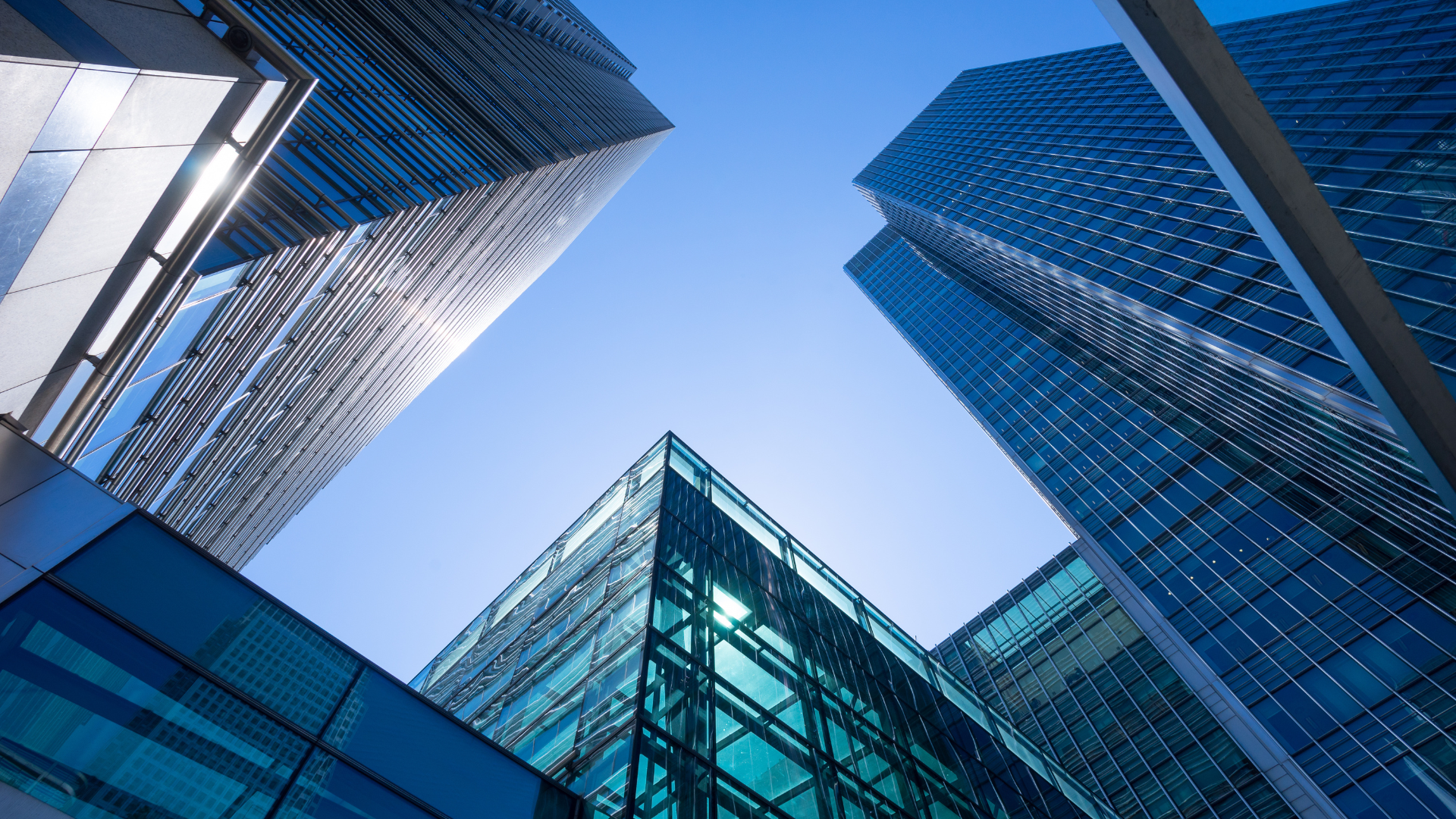 Looking up at a group of tall buildings with a blue sky in the background.