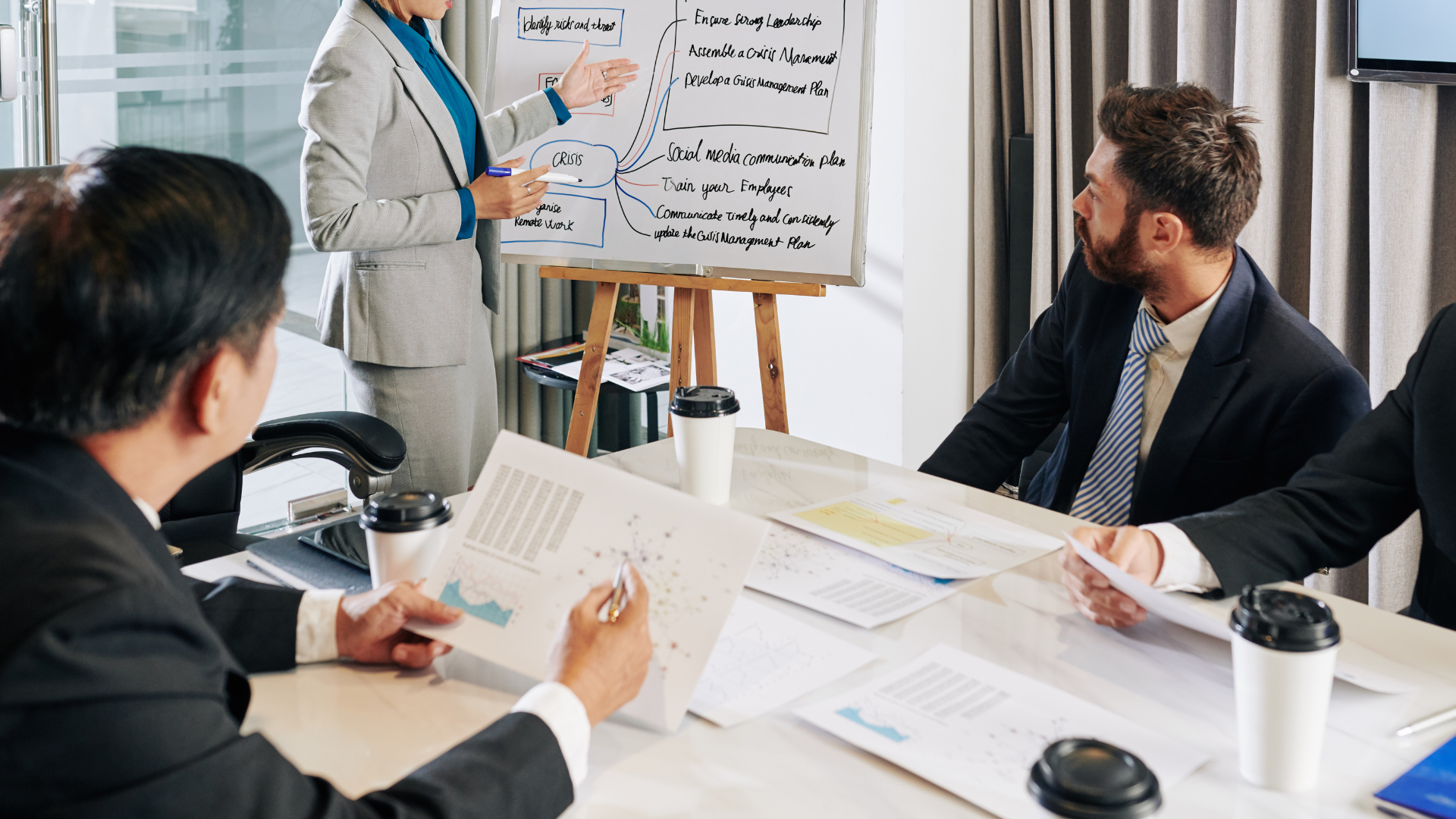 A group of business people are sitting around a table having a meeting.