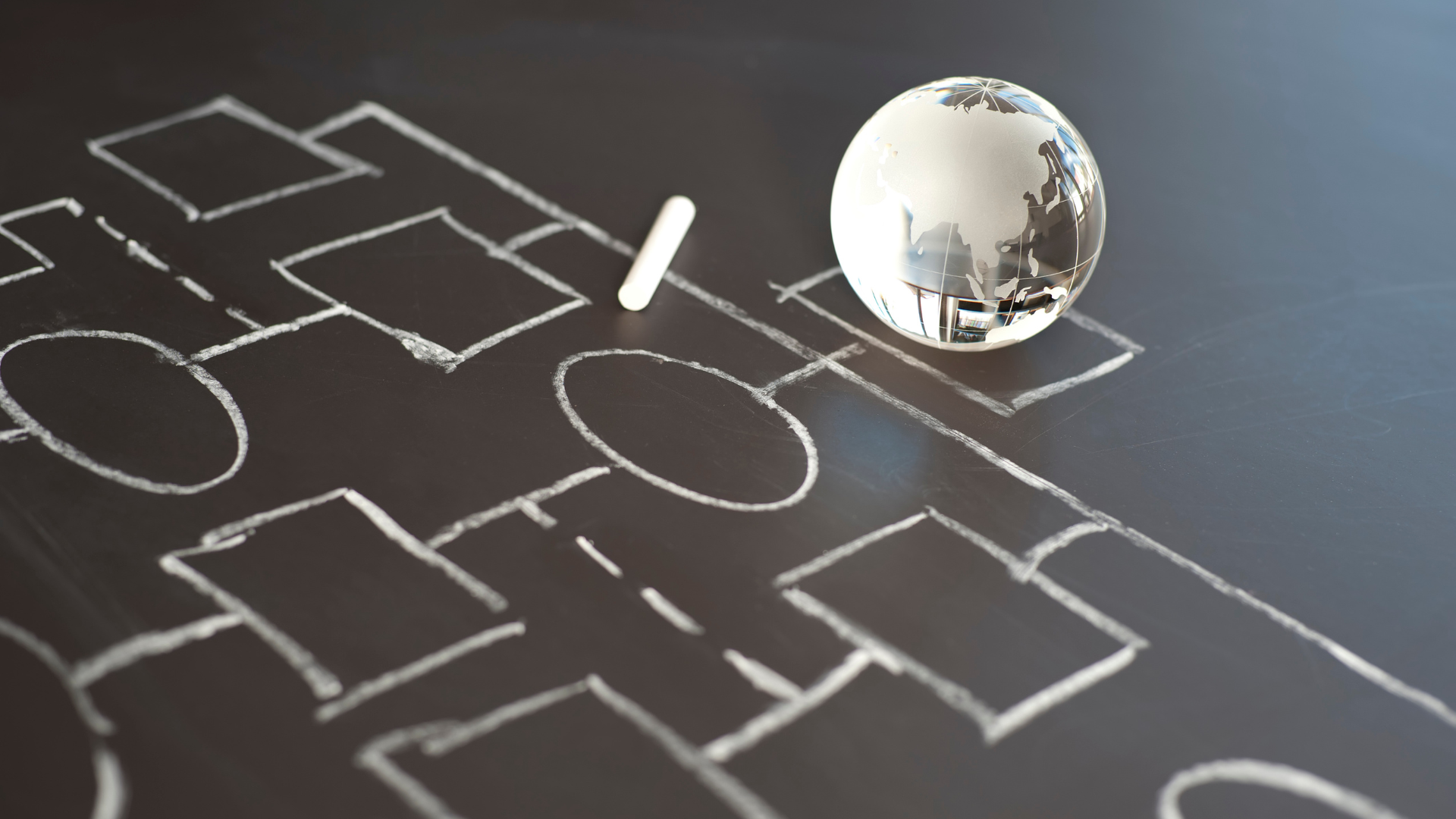 A chalkboard with a drawing of a soccer field and a globe on it
