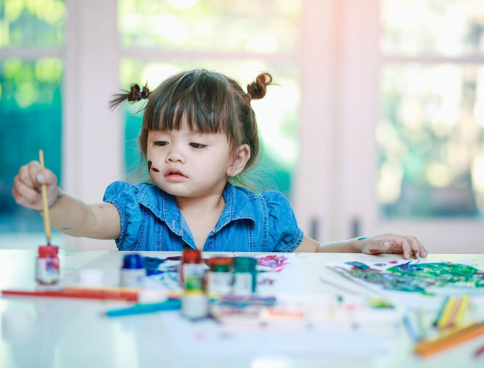 Little Girl with Paint Brush — Raymore, MO — Young Professors Daycare, LLC