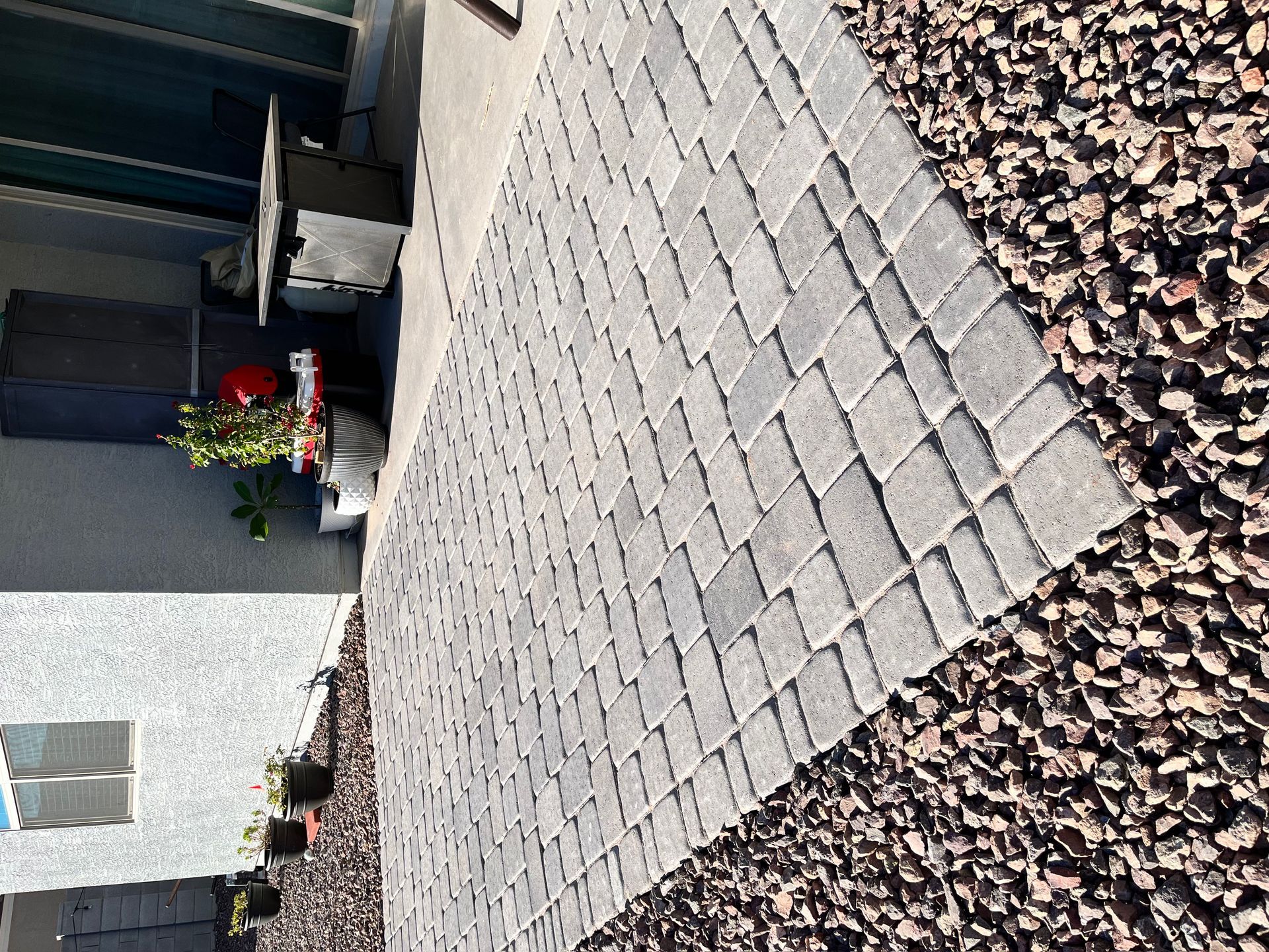 Gray brick patio bordered by brown gravel.