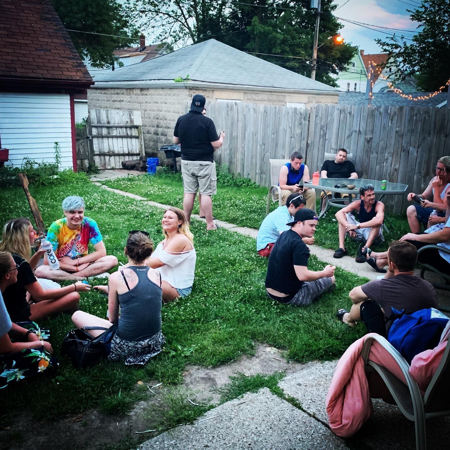 People in a circle, engaged in a group discussion in a light-filled room.