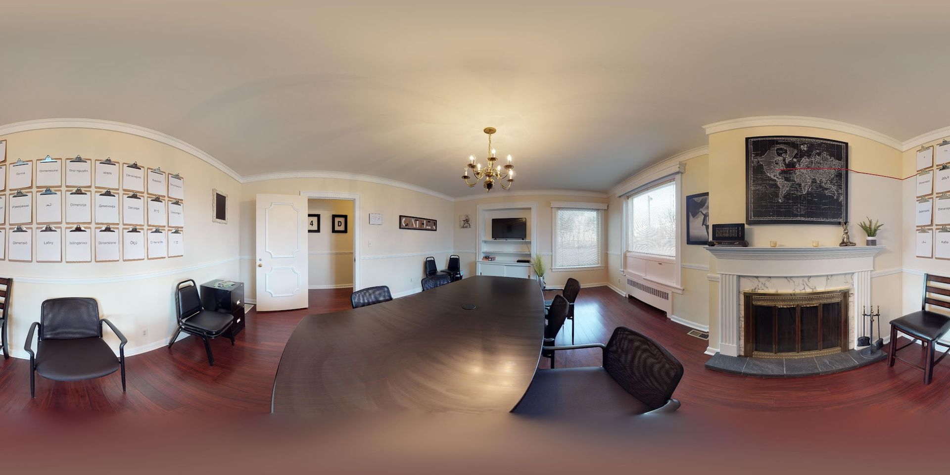 Conference room with a long table, chairs, fireplace, and awards on the walls.