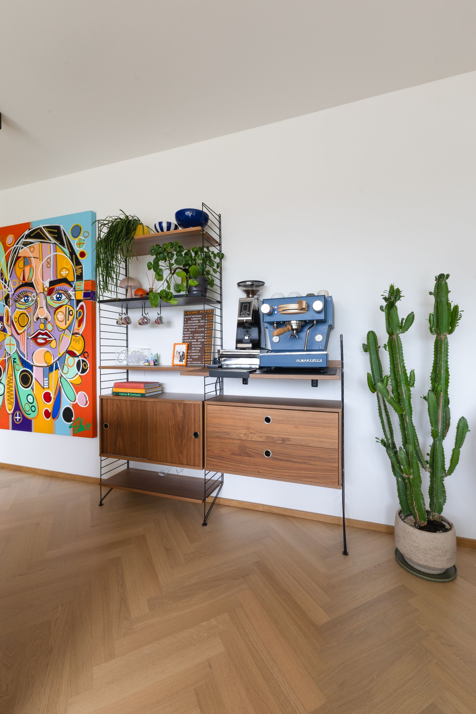 Blaue Espressomaschine, Holzregalen, einem Kaktus und einem farbenfrohen Porträt.Fotograf Tübingen. Fotograf Reutlingen.