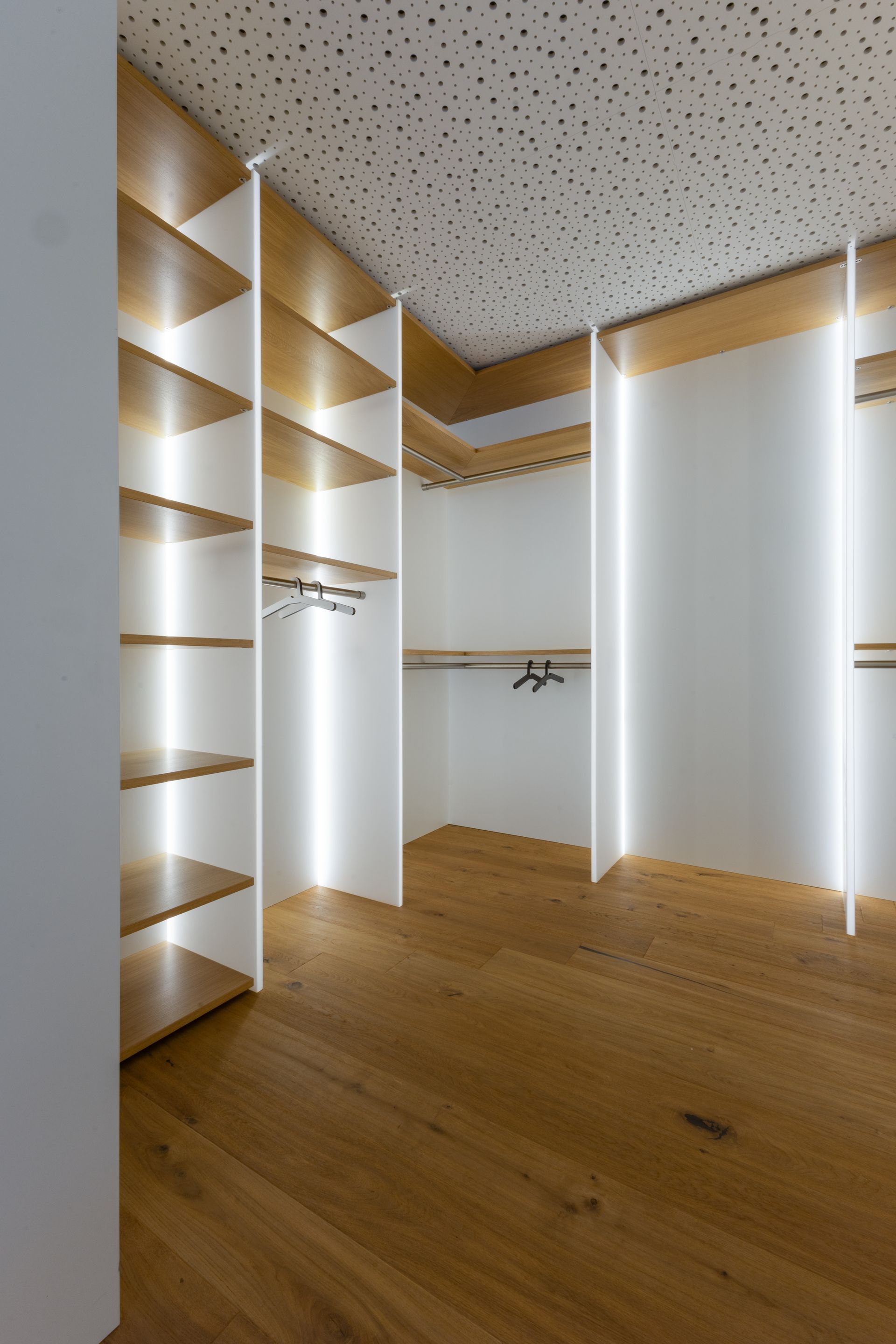 Regale in begehbaren Kleiderschrank mit weißen Wänden und LED-Beleuchtung.Fotograf Tübingen. Fotograf Reutlingen.