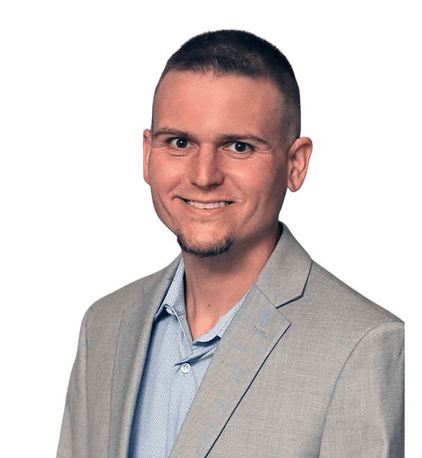 A man in a suit and blue shirt is smiling for the camera.